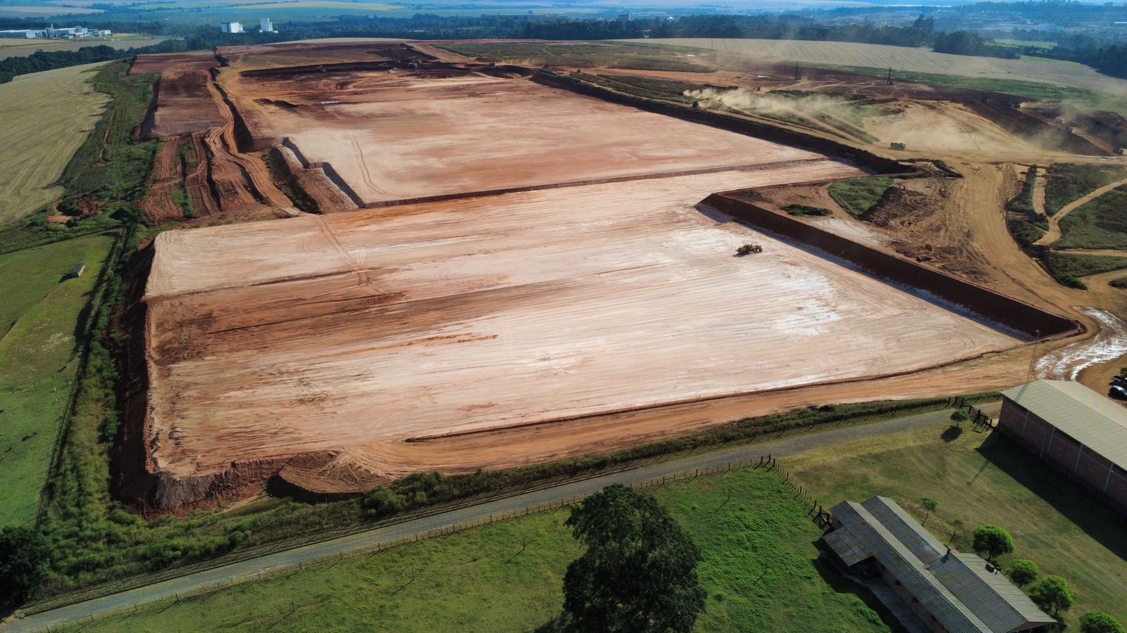 Vista aérea do terreno em obras da fábrica da XBRI e LingLong em Ponta Grossa, com o solo nivelado e máquinas trabalhando