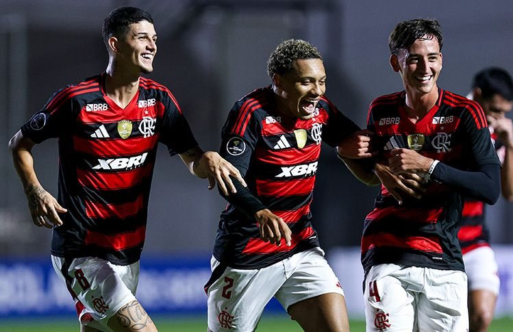 Three Flamengo U-20 players celebrate a goal wearing the XBRI shirt